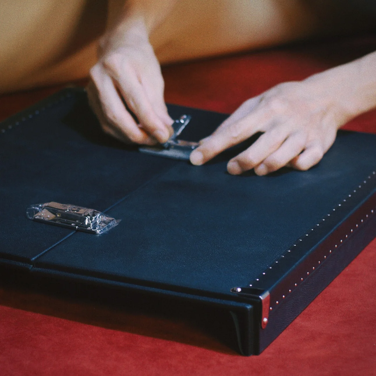 Hands marking the position of a fitting on a black case
