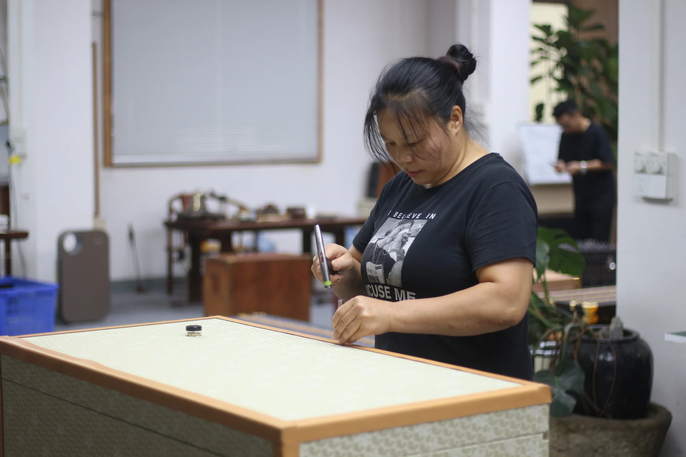 A Pusu Atelier maker hand-finishing a case in the Guangzhou workshop