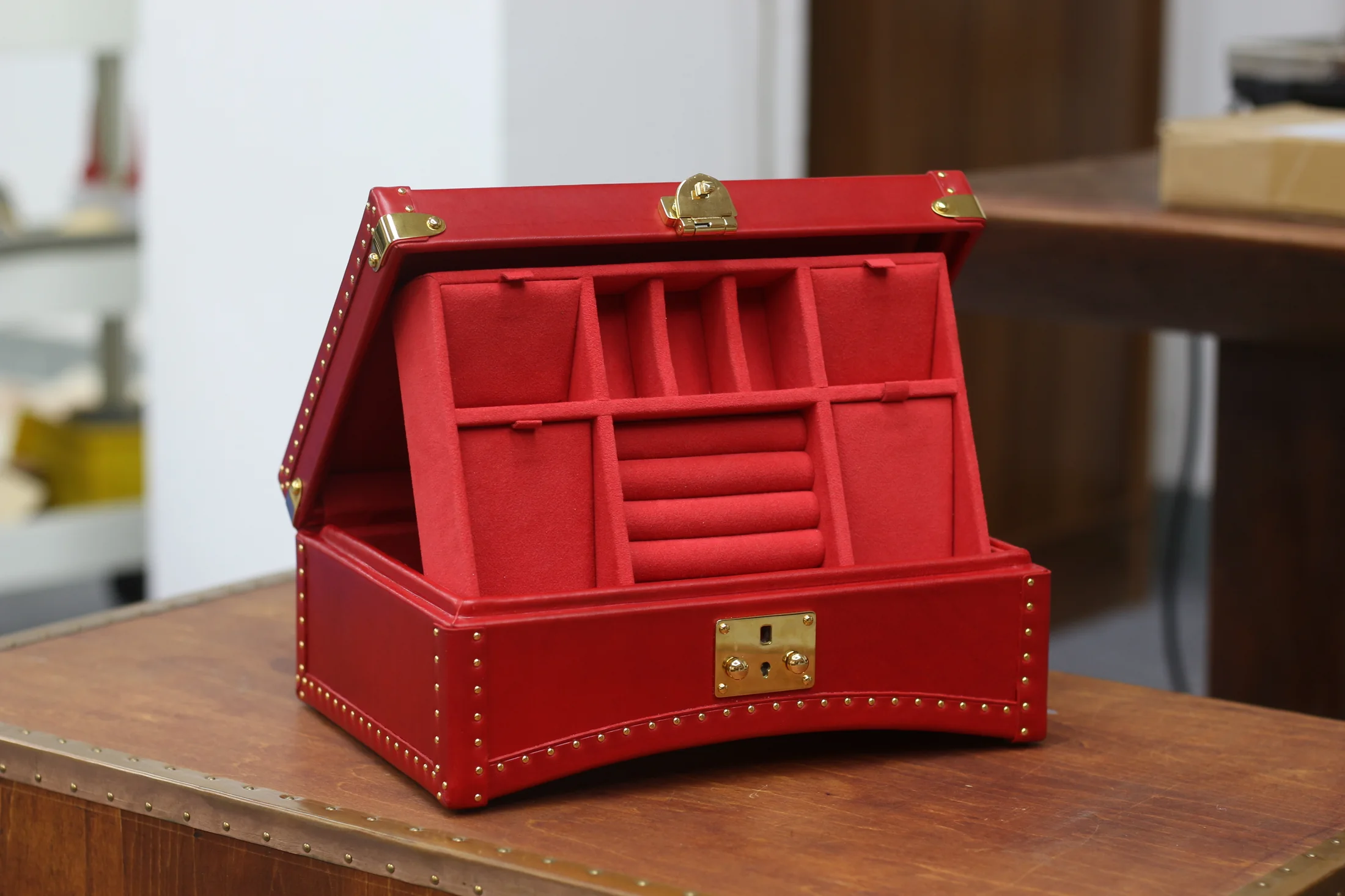 Open red jewelry case with organized compartments