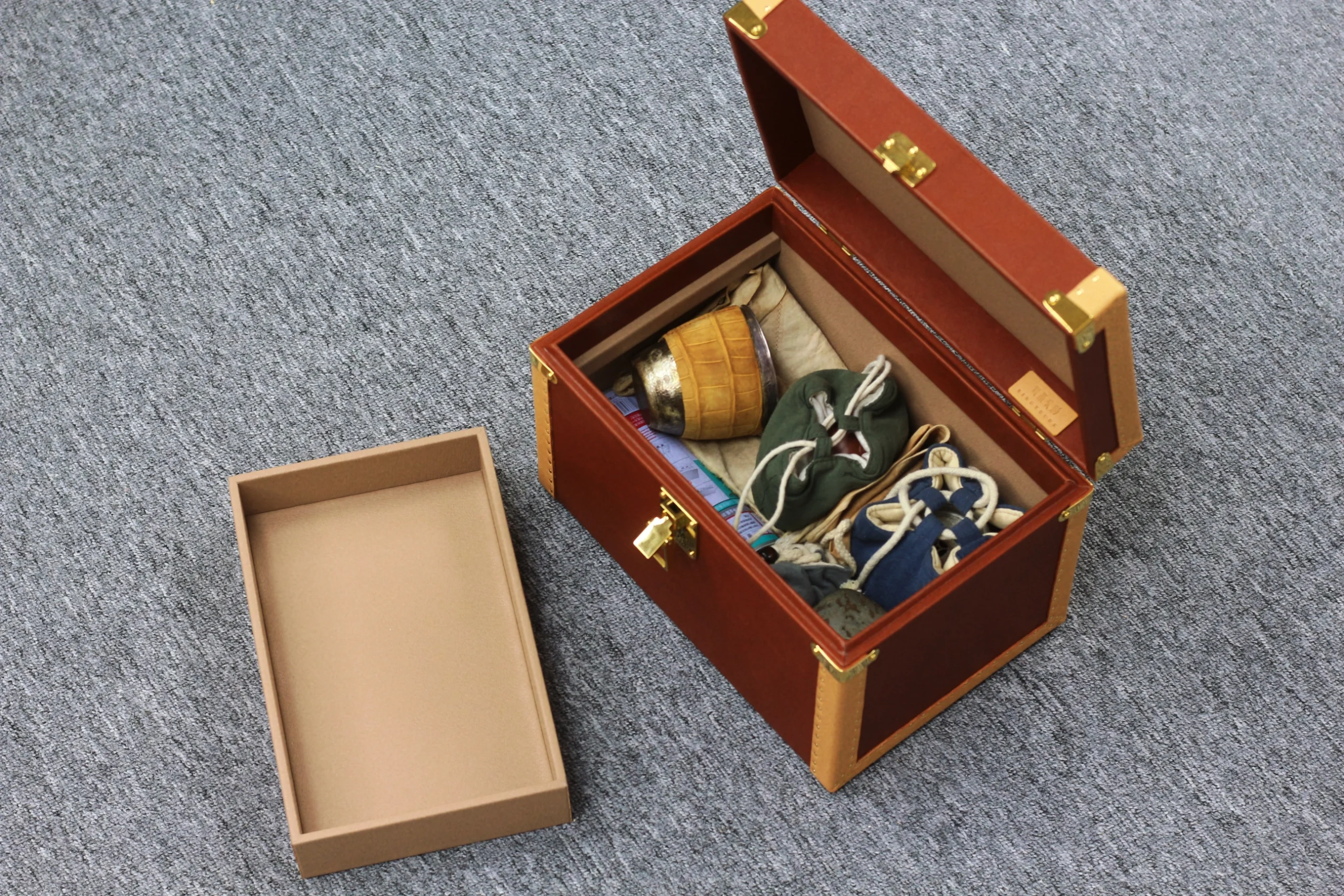 Handmade leather storage case on wooden desk with tea ware